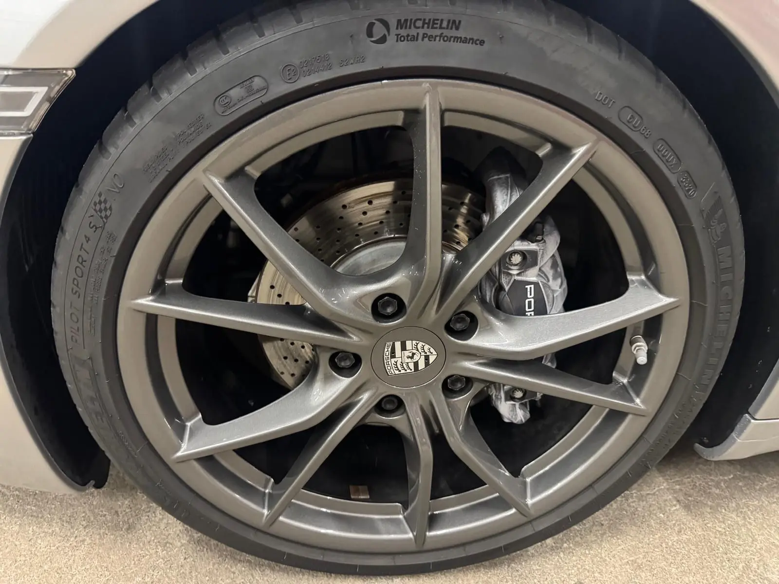 Gros plan sur la jante Carrera S 20 pouces gris foncé avec étrier de frein Porsche et pneu Michelin Pilot Sport.