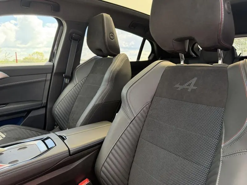 Vue intérieure rapprochée des sièges avant en Alcantara noir et cuir avec logo Alpine brodé sur le dossier.