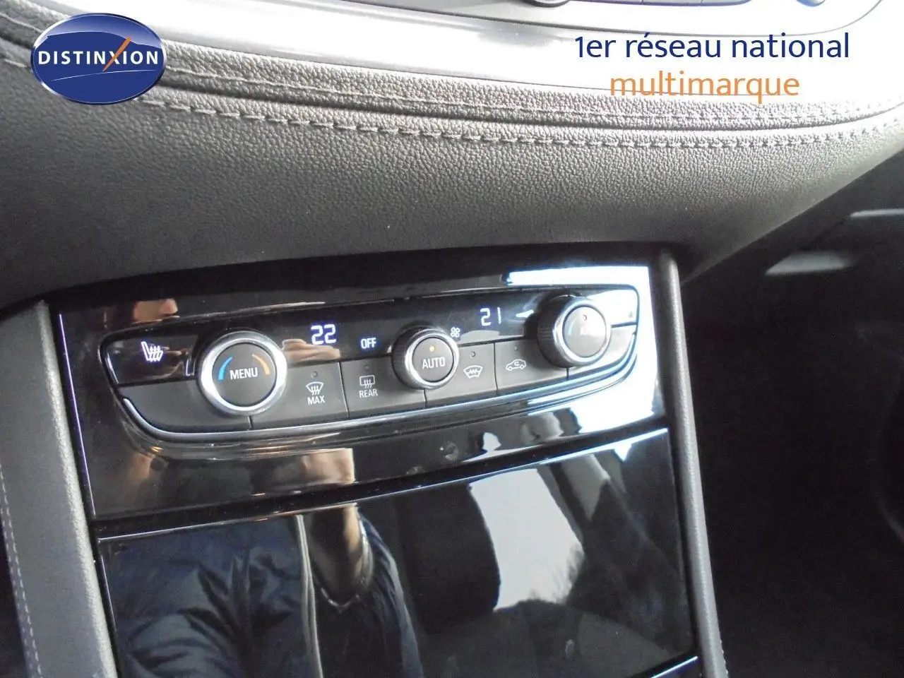 Gros plan sur la console centrale du Grandland X 2021, mettant en valeur les commandes de climatisation et les finitions noires brillantes.