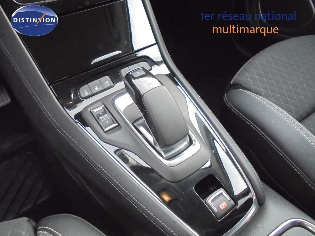 Le levier de vitesses automatique et les commandes de mode de conduite dans l'habitacle noir de l'Opel Grandland X hybride.