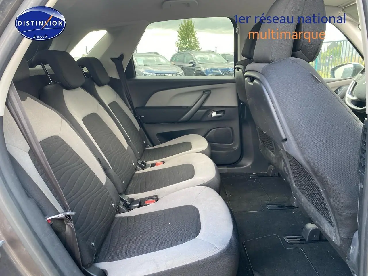 Vue intérieure de la deuxième rangée de sièges individuels gris et noir du Citroën C4 Picasso 2016 côté gauche.