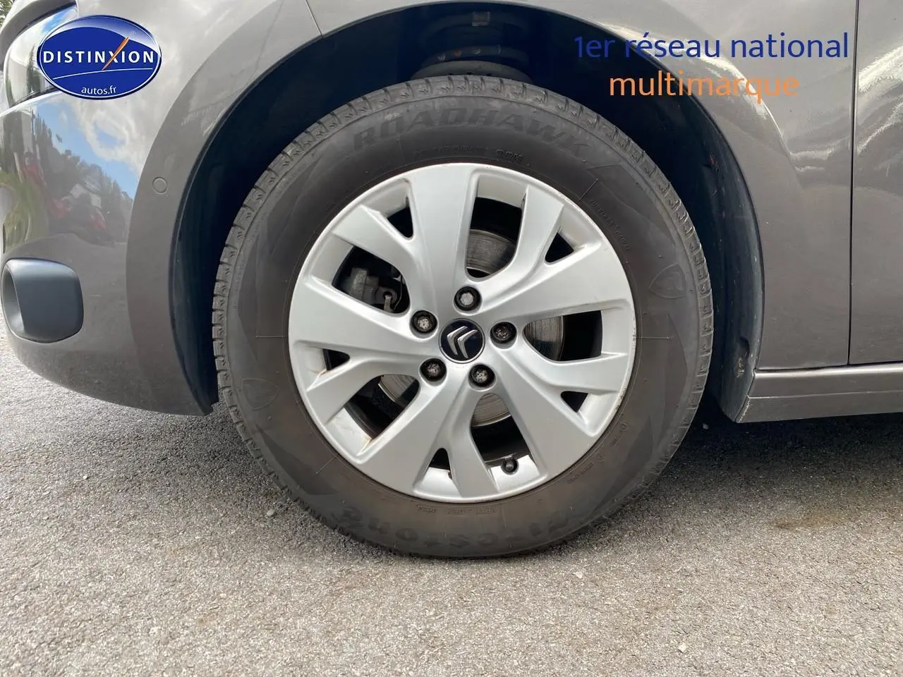 Gros plan sur la roue avant gauche grise d'une Citroën C4 Picasso BlueHDi 120 intensive de 2016.