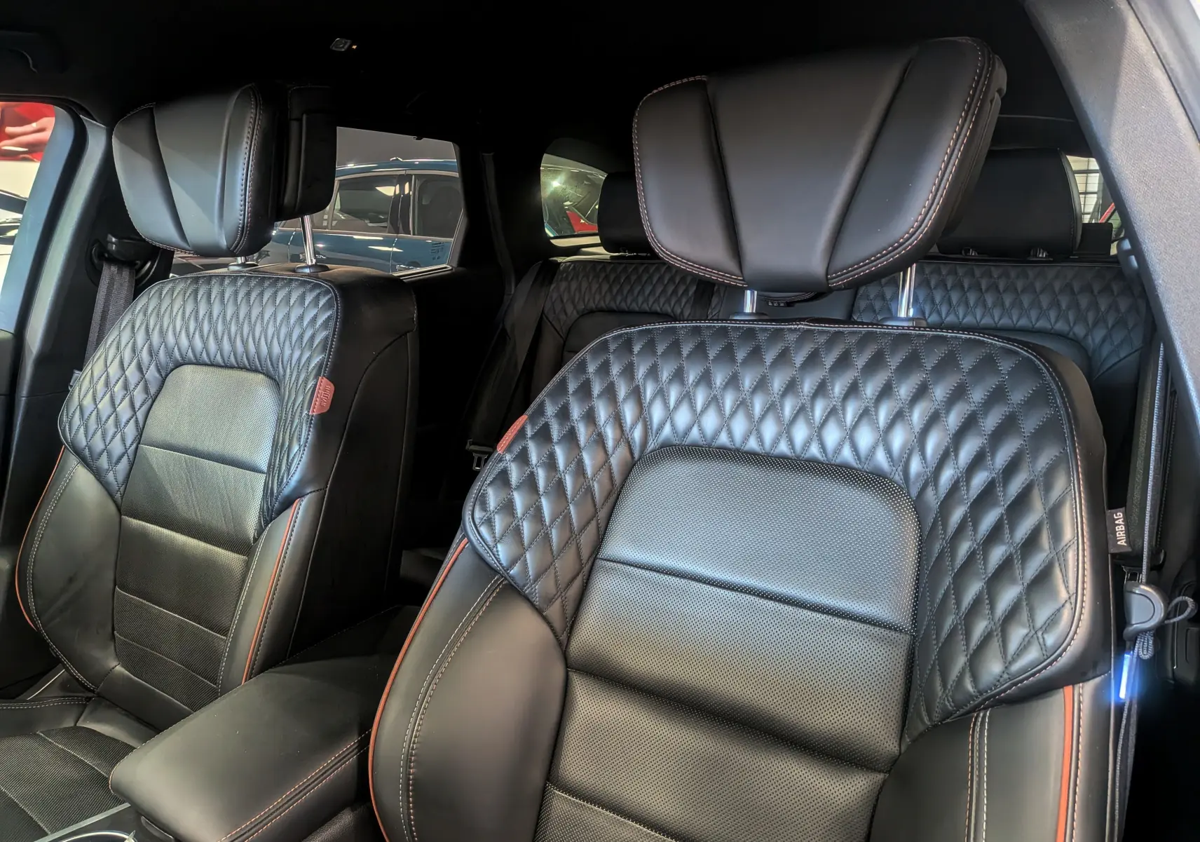 Gros plan sur les sièges avant en cuir noir matelassé avec surpiqûres rouges de la Renault Talisman Estate 2022.
