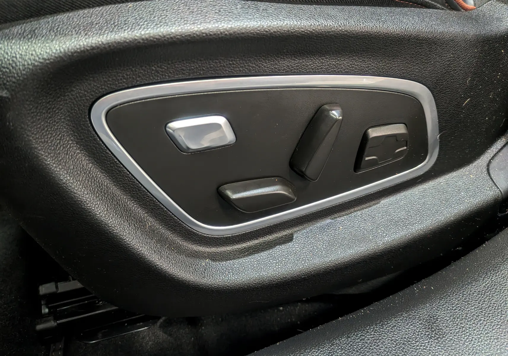 Commandes électriques de réglage du siège conducteur en cuir noir dans une Renault Talisman Estate gris Cassiopé, vue rapprochée.