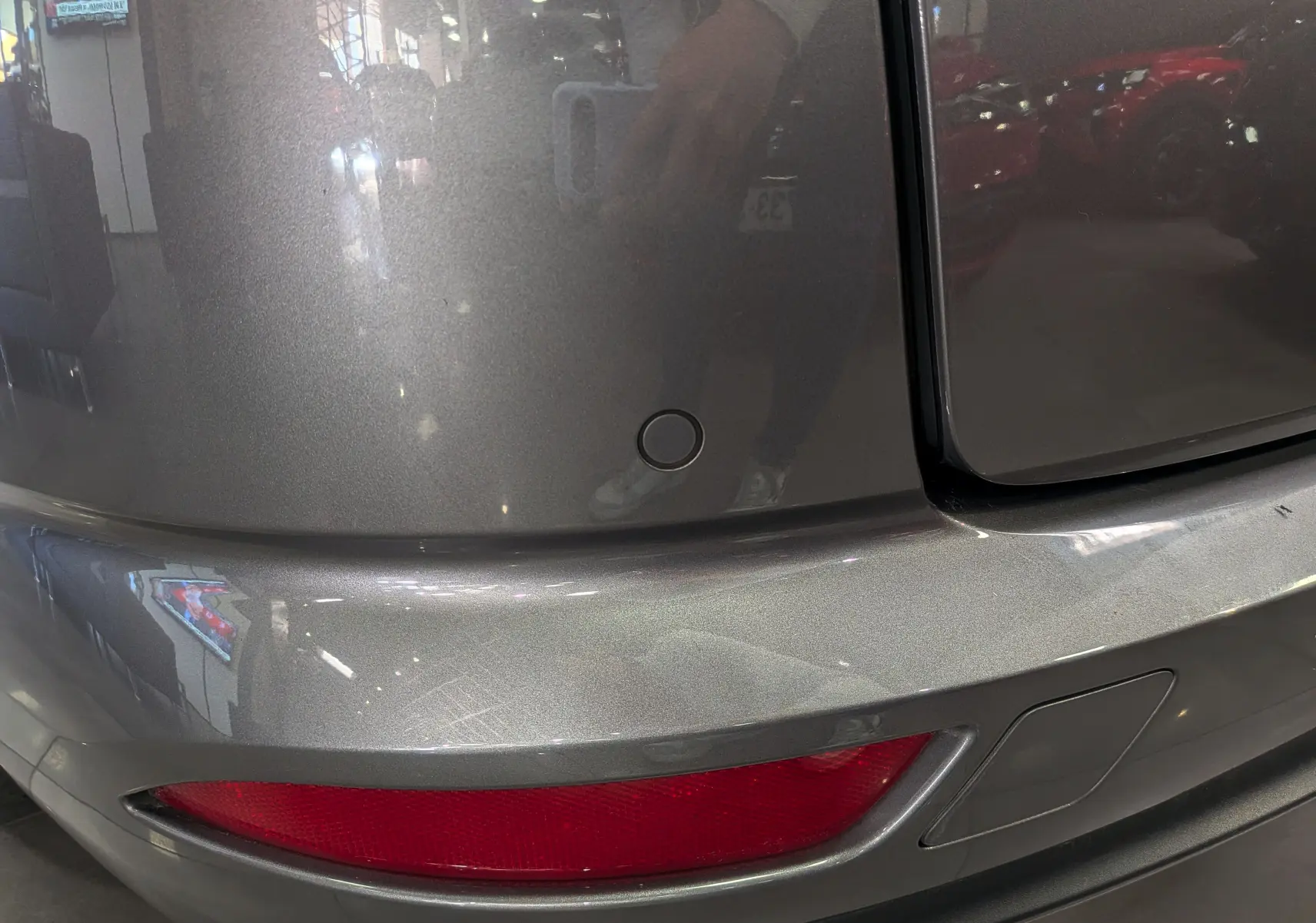 Gros plan sur le pare-chocs arrière gris Cassiopé d'une Renault Talisman Estate 2022 avec feu rouge et capteur de recul.