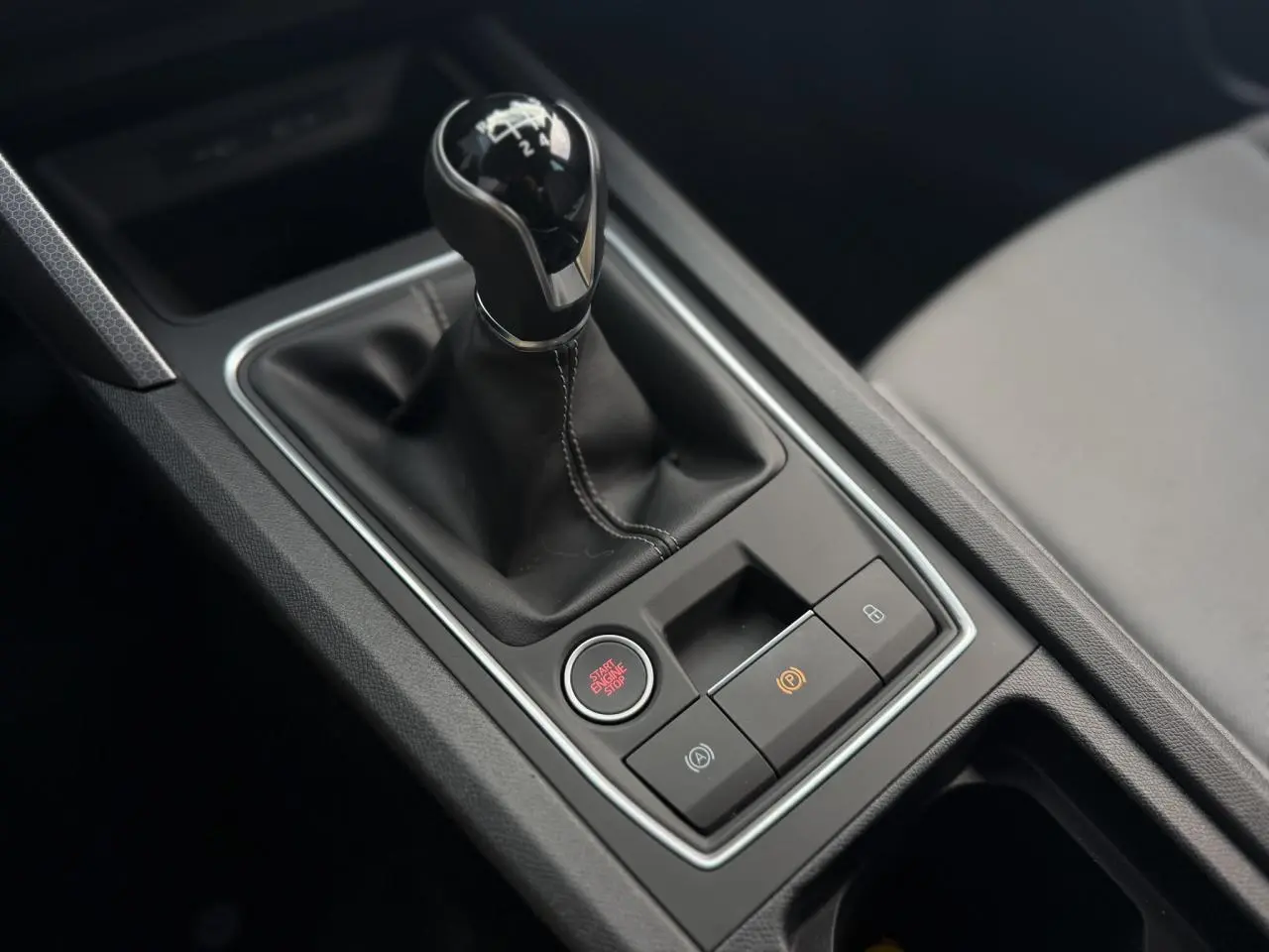 Gros plan sur la console centrale du SEAT LEON ST 1.5 TSI 115 Style 2025 avec levier de vitesse manuel et bouton start/stop.