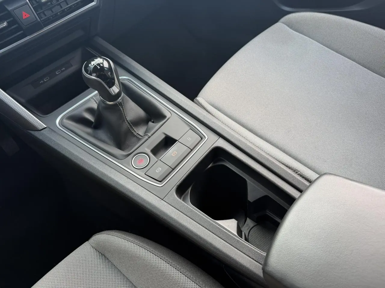 Vue rapprochée de la console centrale de la SEAT LEON ST 1.5 TSI 115 Style avec levier de vitesse manuel et sellerie textile grise.