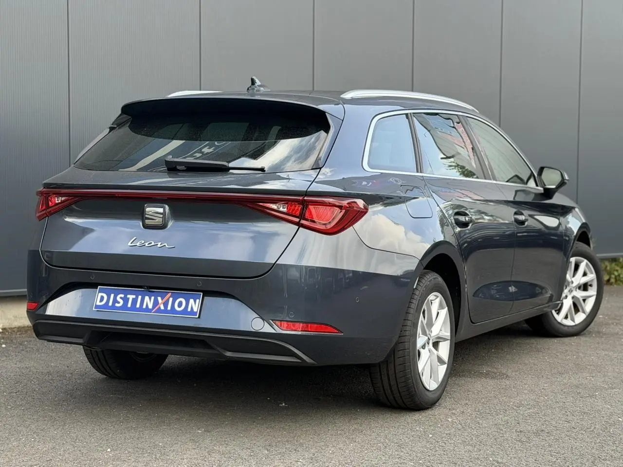 Vue 3/4 arrière droite d'une SEAT Leon ST gris magnétique avec feux arrière LED et jantes alliage 16 pouces.