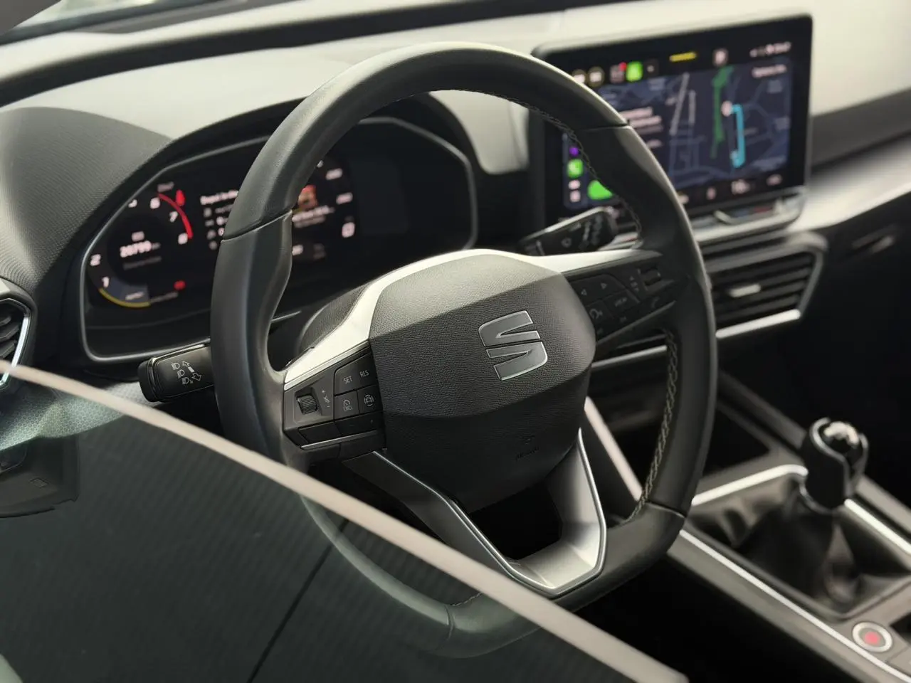 Vue rapprochée du volant cuir multifonction et levier de vitesses manuelle dans l’habitacle moderne d’une SEAT LEON ST 2025.
