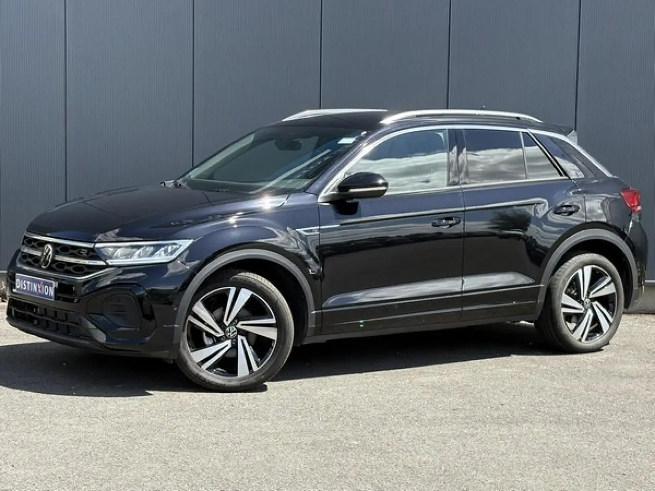Volkswagen T-Roc noir intense en vue de profil côté gauche, avec jantes alliage 18" Nevada et détails R-Line visibles.