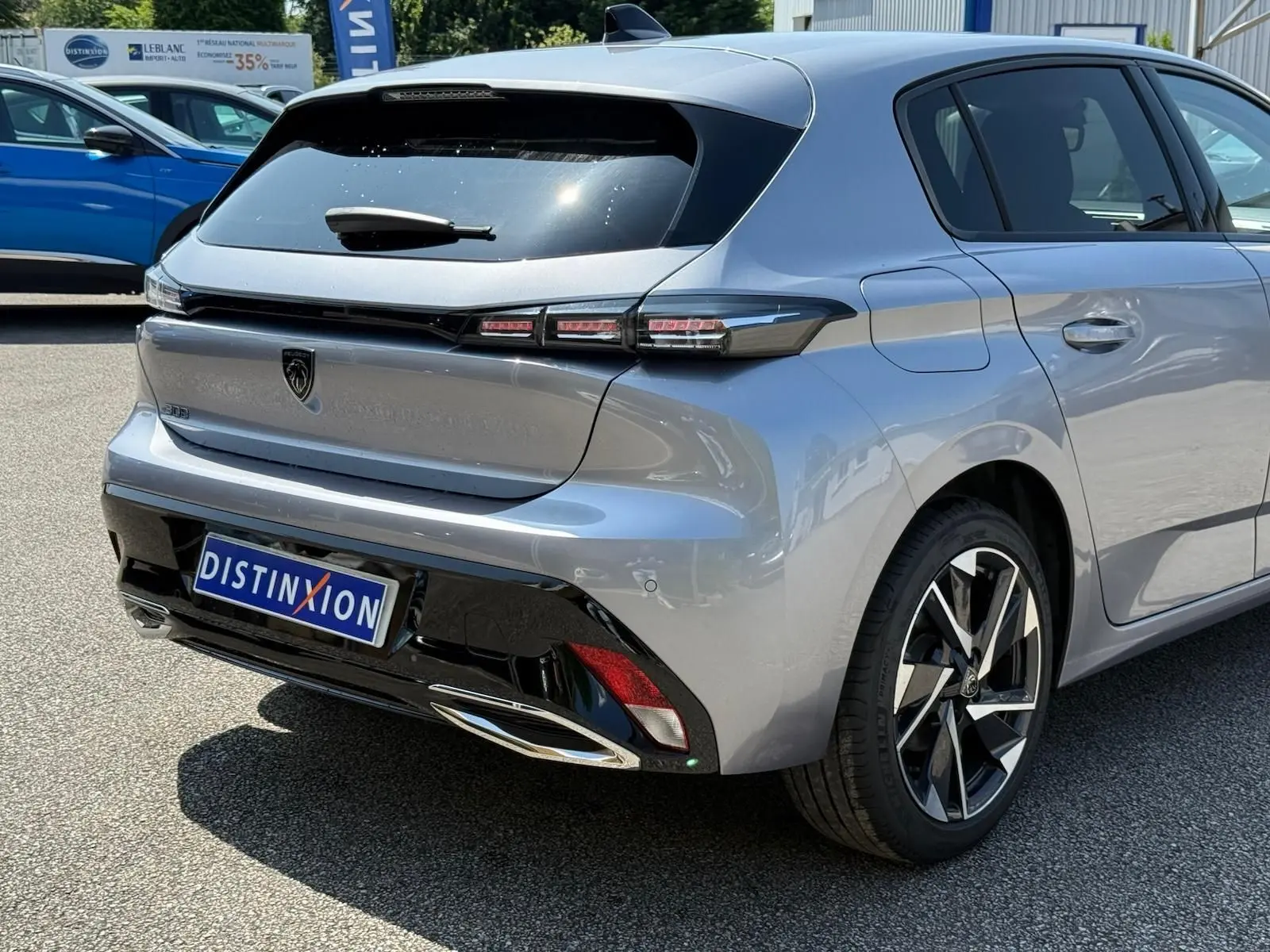 Vue 3/4 arrière droite d'une Peugeot 308 gris Artense avec feux LED et jantes alliage distinctives.