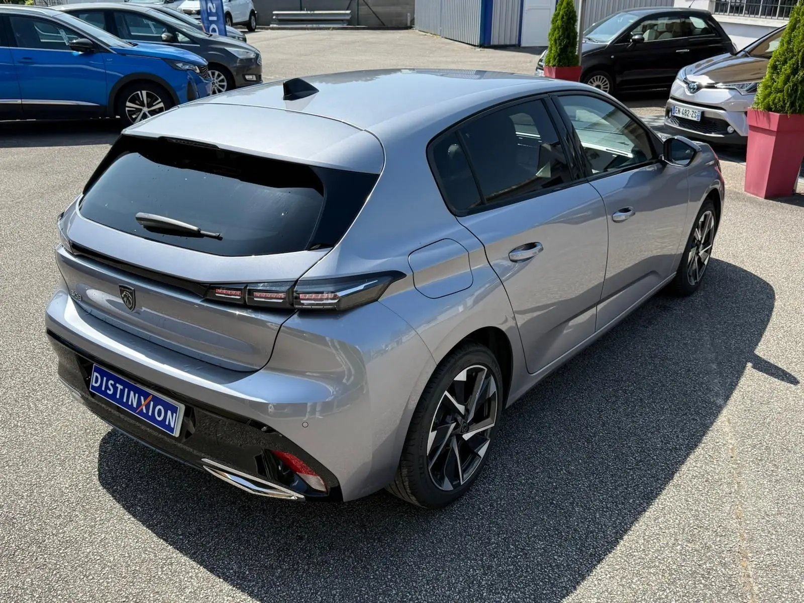 PEUGEOT 308 gris Artense vue 3/4 arrière droit, avec feux LED distinctifs et jantes alliage modernes.