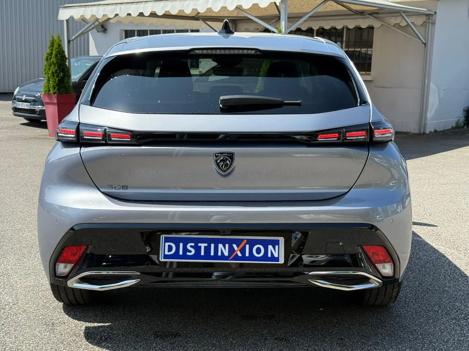 Vue arrière d'une Peugeot 308 gris Artense 2024 avec feux LED distinctifs et double sortie d'échappement chromée.