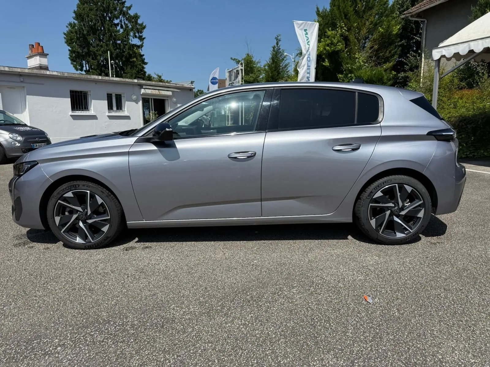 Profil côté gauche d'une Peugeot 308 2024 gris Artense avec jantes alliage au design moderne.