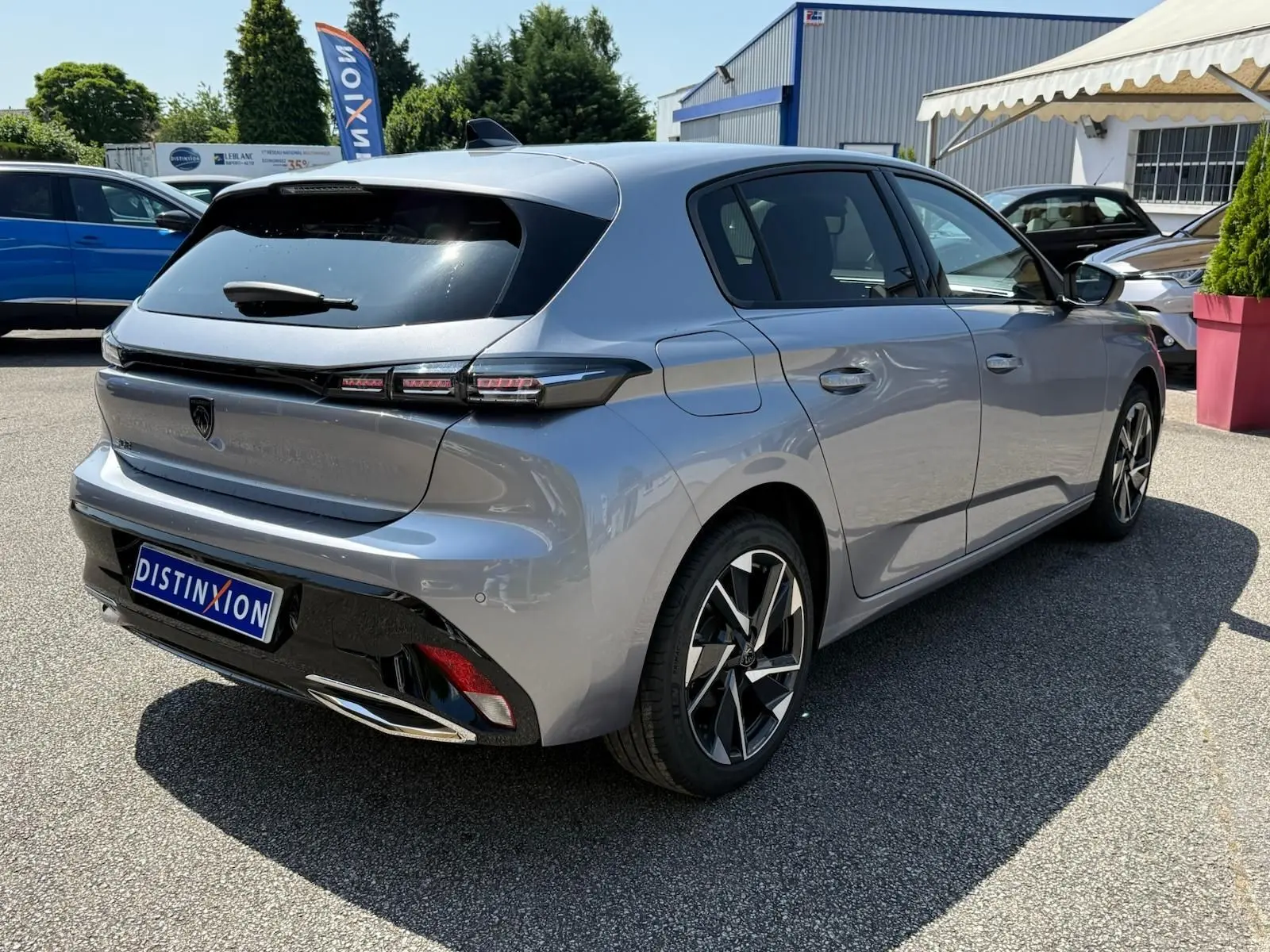 Peugeot 308 gris Artense vue 3/4 arrière droit, avec feux arrière LED et jantes alliage distinctives.