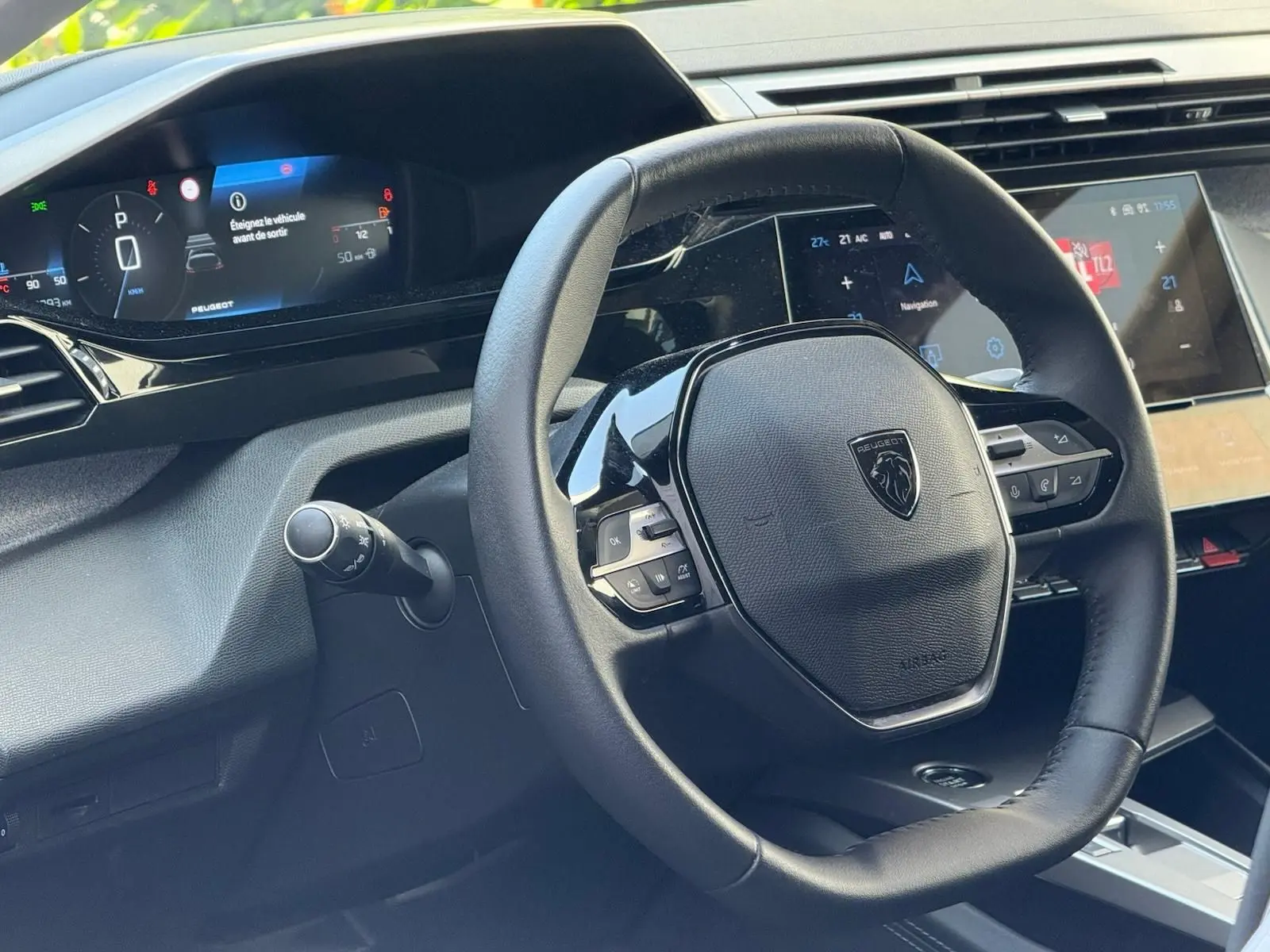 Vue rapprochée du volant cuir noir et du tableau de bord numérique de la Peugeot 308 gris Artense 2024.