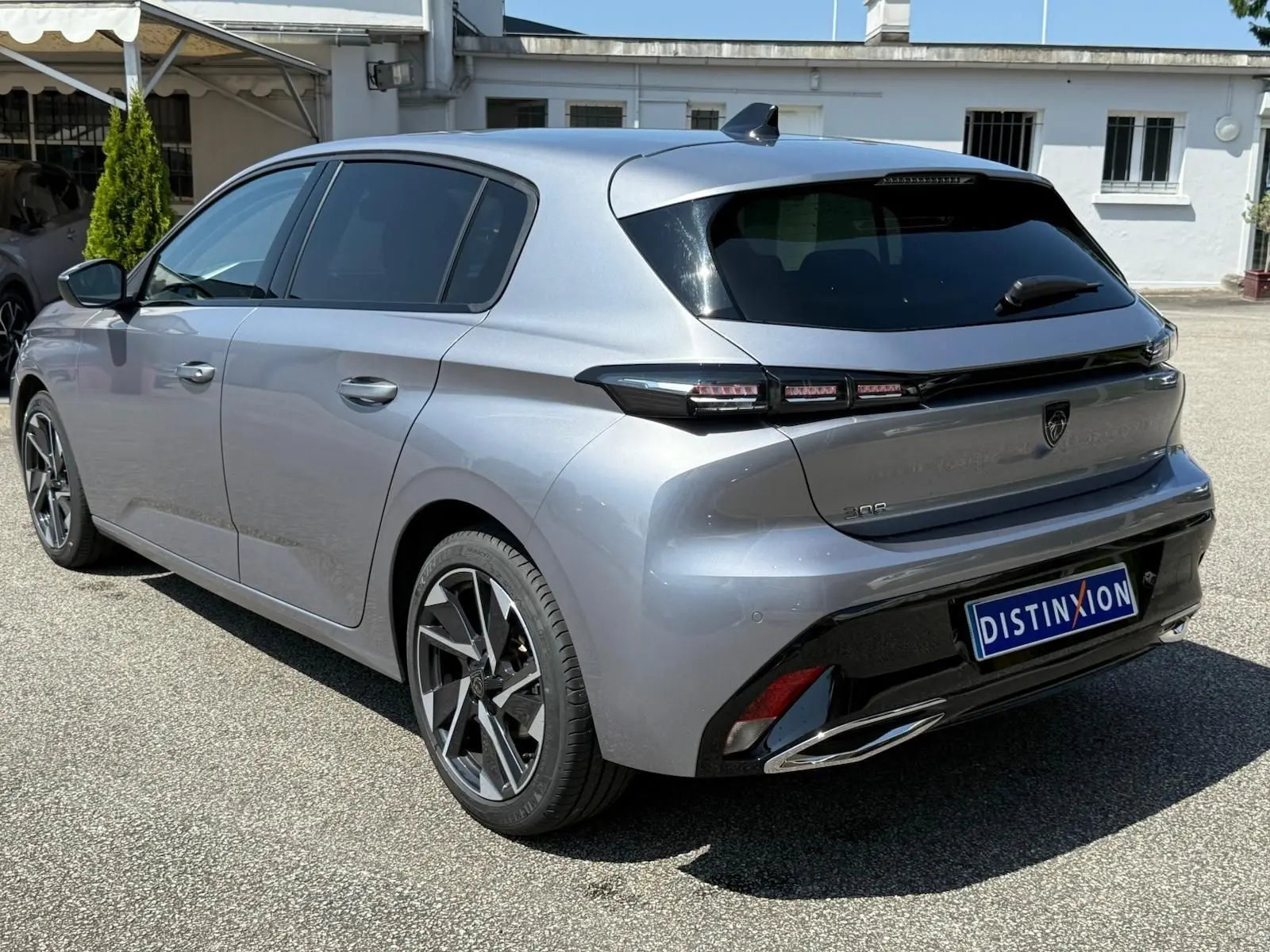 Peugeot 308 gris Artense vue 3/4 arrière droit, avec feux arrière LED et jantes alliage distinctives.
