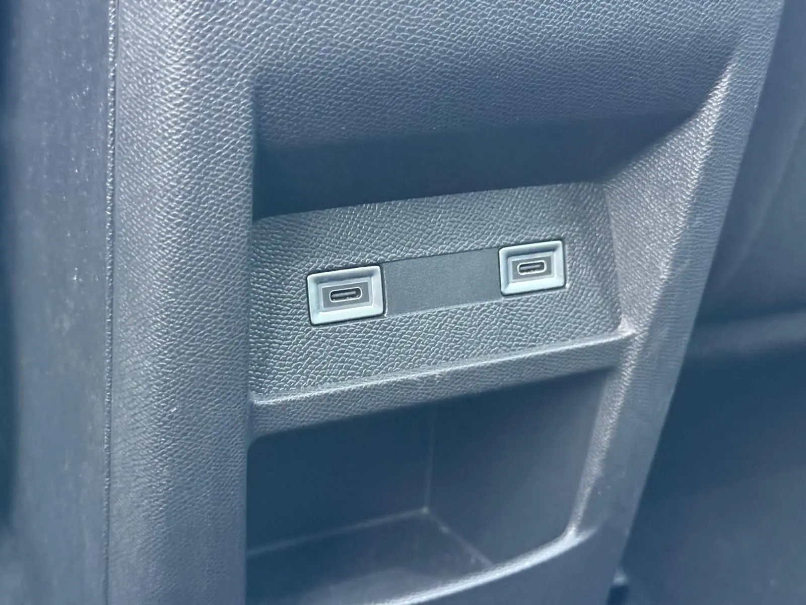 Gros plan sur deux ports USB intégrés dans la console arrière d'une Peugeot 308 gris Artense 2024.