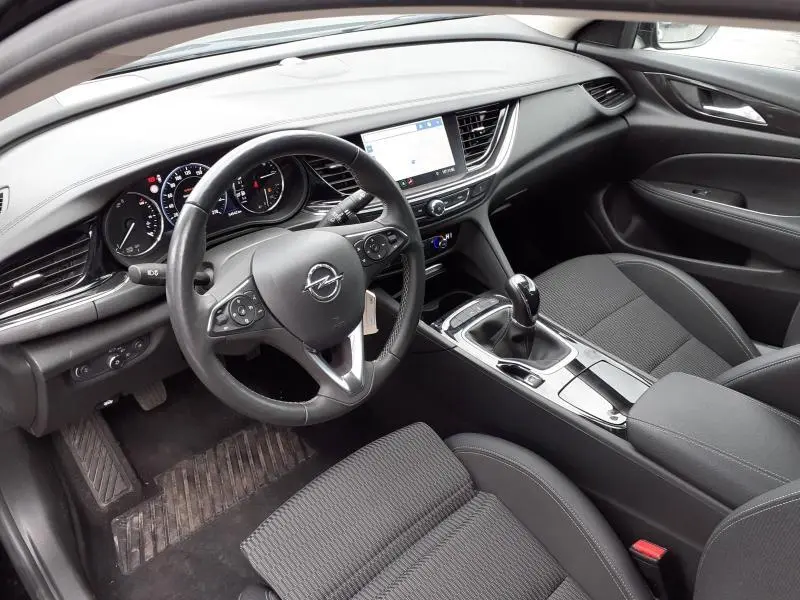 Intérieur noir de l'Opel Insignia Grand Sport 2021, vue côté conducteur avec tableau de bord et écran tactile central.