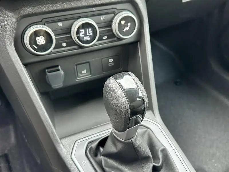 Le levier de boîte automatique noir brillant du Dacia Jogger 1.6 hybrid vu en gros plan avec commandes climatiques.