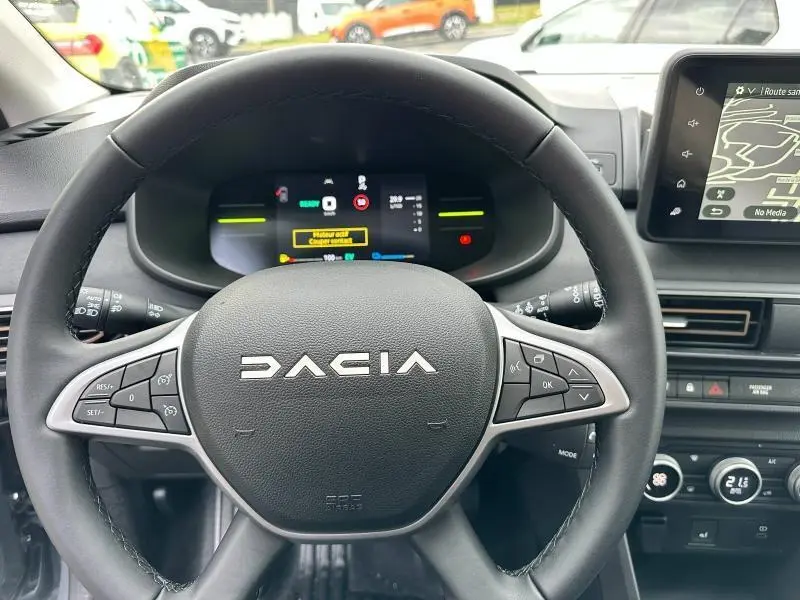 Vue rapprochée du volant DACIA Jogger 2025 avec commandes intégrées et tableau de bord numérique allumé.