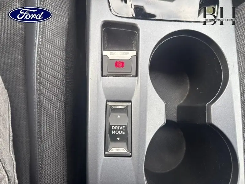Gros plan sur la console centrale grise avec bouton frein à main électronique et sélection mode de conduite d'une Peugeot 2008 blanc banquise.