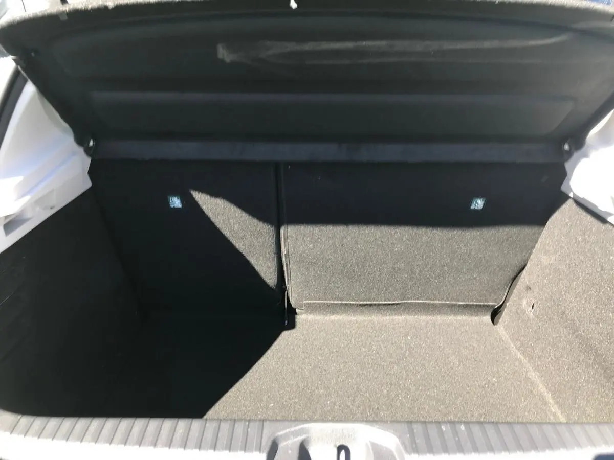 Coffre ouvert d'une Renault Clio Gris Urban 2021, vue intérieure montrant l'espace de chargement et banquette rabattable.