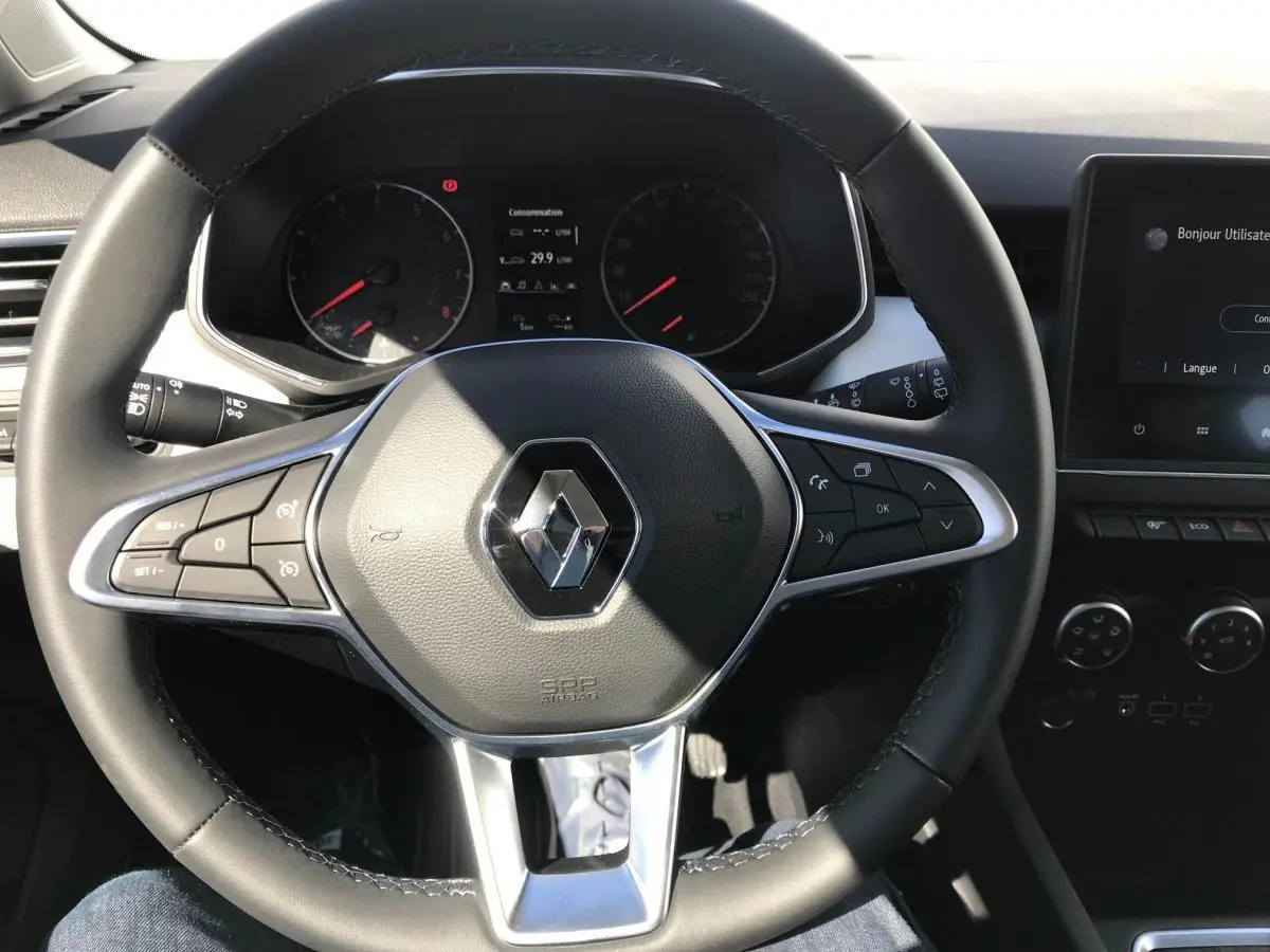 Volant TEP multifonctions Renault Clio 2021 vu de face, avec tableau de bord et écran tactile en arrière-plan.