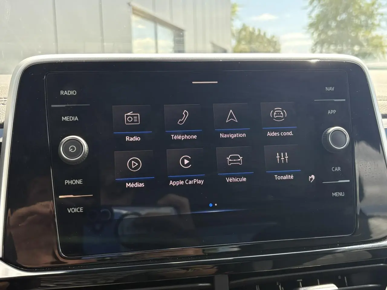 Écran tactile central du Volkswagen T-Roc 2025 affichant les options Apple CarPlay et aides à la conduite.