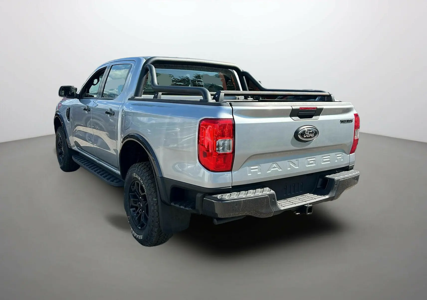 Ford Ranger 2025 gris iconic vu en 3/4 arrière droit avec barres de protection et pneus tout-terrain