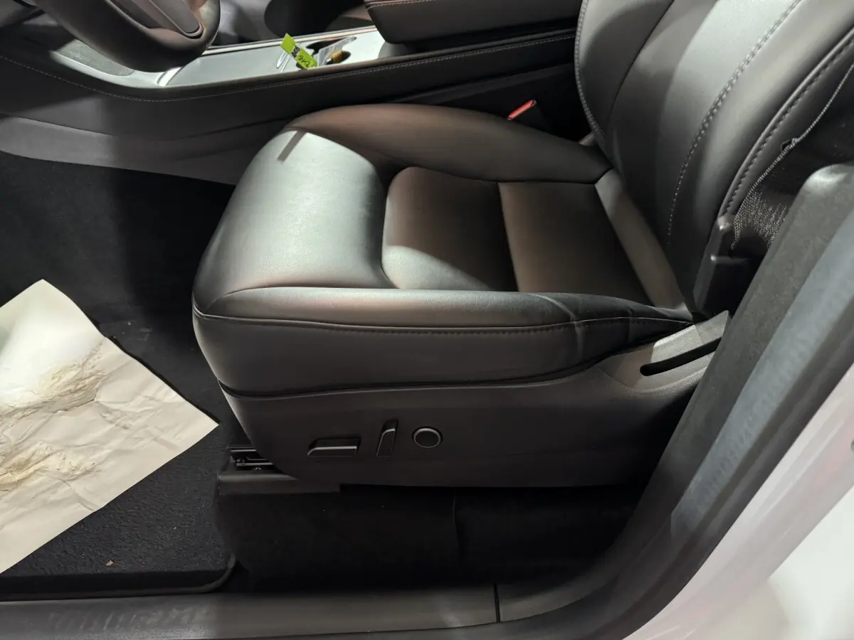 Siège avant droit en cuir noir de la Tesla Model Y blanc, version Grand Autonomie Dual Motor 2022, vue intérieure rapprochée.