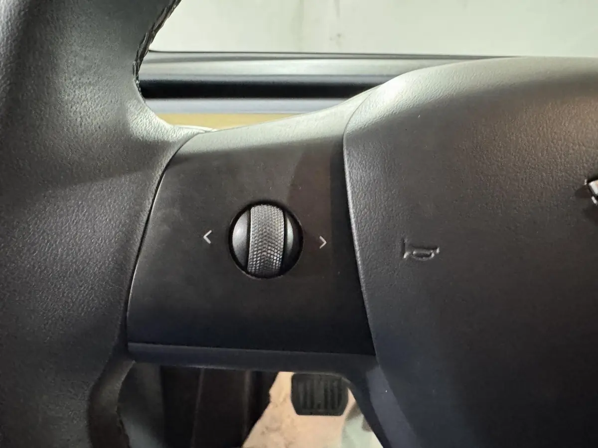 Gros plan sur la molette de réglage du volant noir du Tesla Model Y Grand Autonomie 2022.