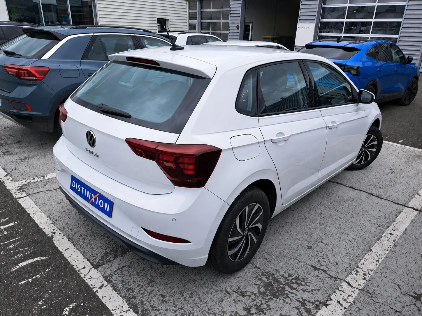 Vue 3/4 arrière droite d'une Volkswagen Polo blanche 2023 avec feux arrière LED et jantes alliage noires.