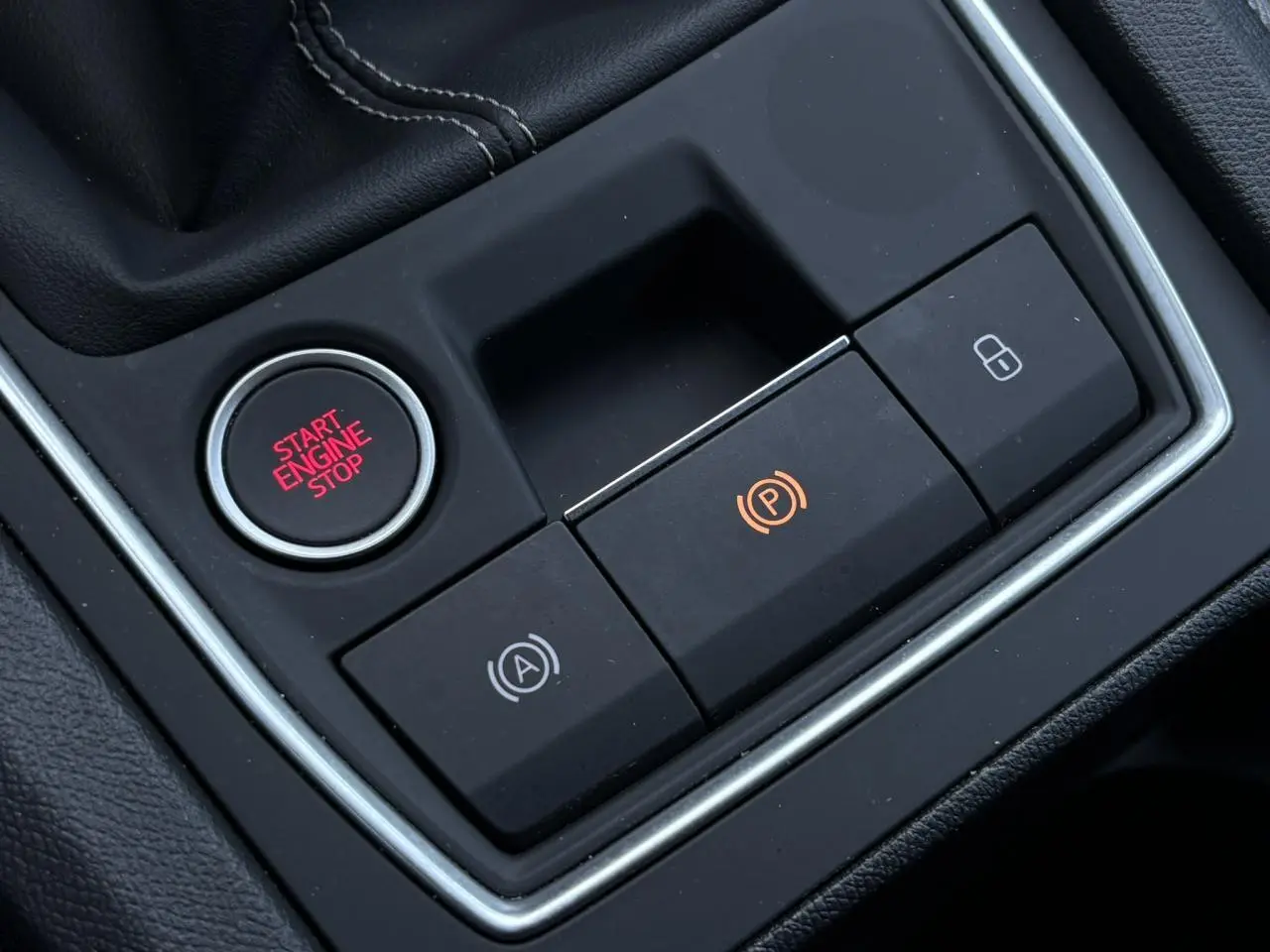 Gros plan sur la console centrale de la SEAT LEON ST 1.5 TSI 115 Style, boutons start/stop et frein électrique visibles.