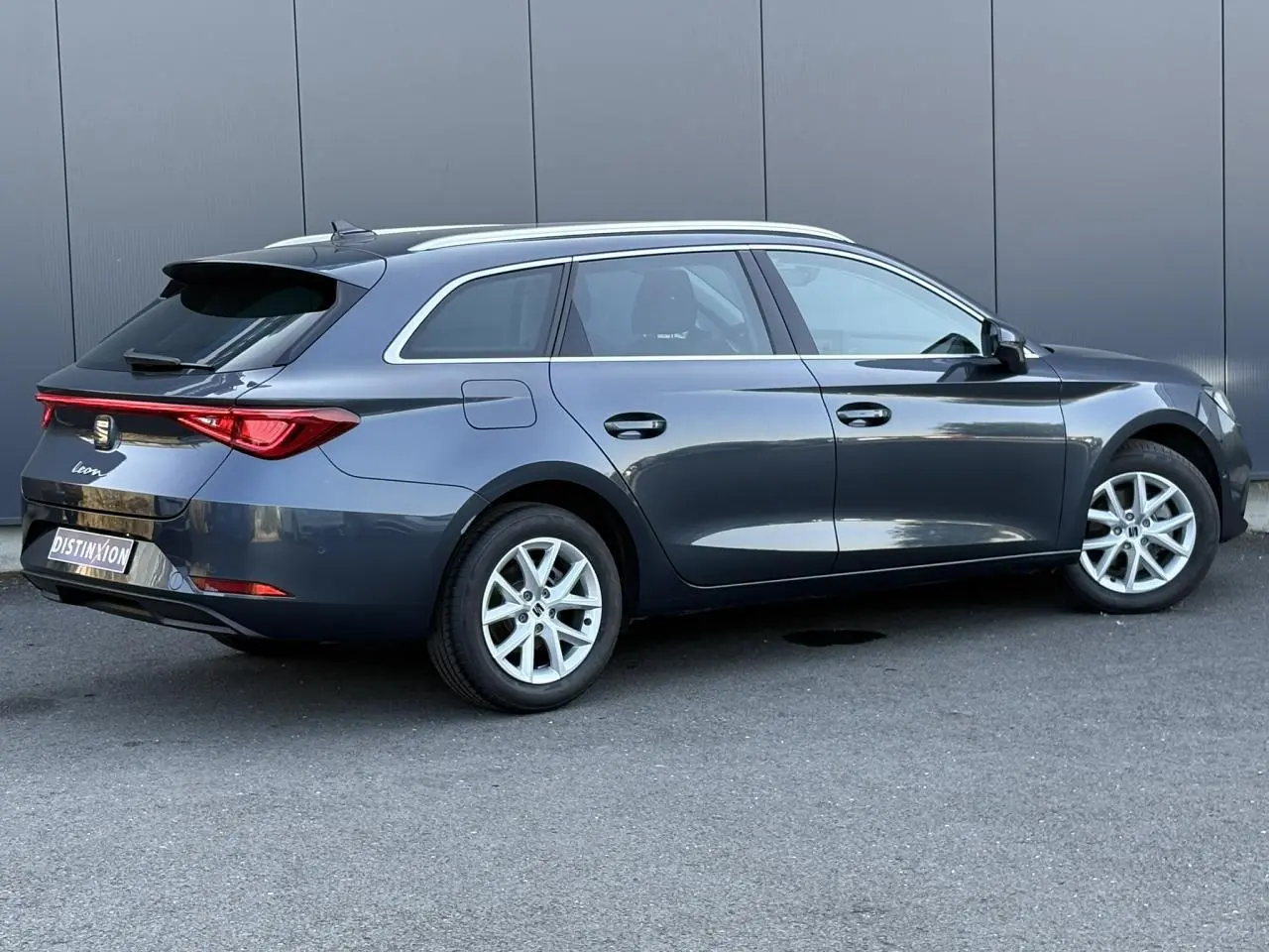 SEAT Leon ST 1.5 TSI gris magnétique vue côté droit en 3/4 arrière avec jantes alliage 16 pouces.