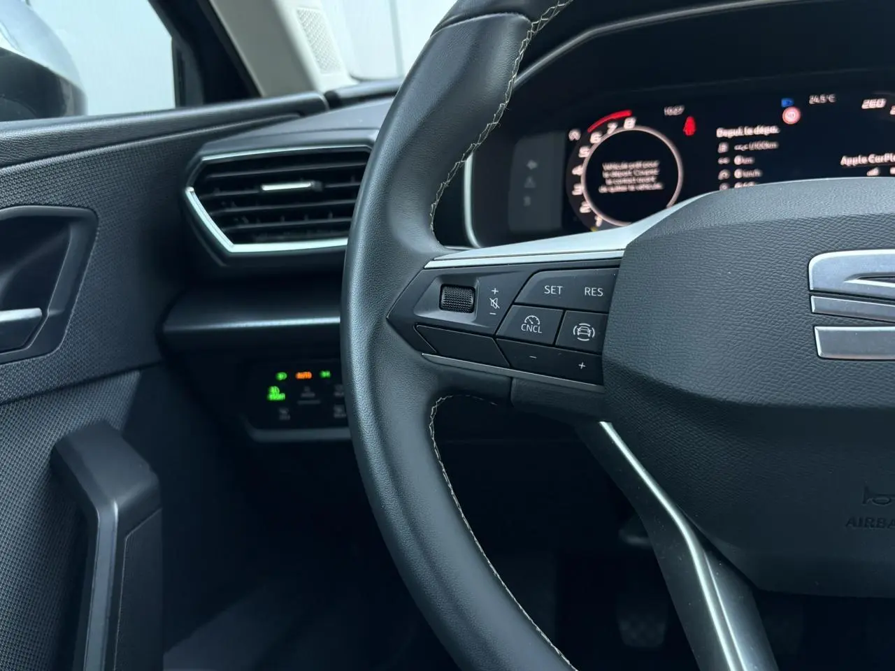 Gros plan sur le volant cuir multifonction et le tableau de bord numérique de la SEAT LEON ST 2025.