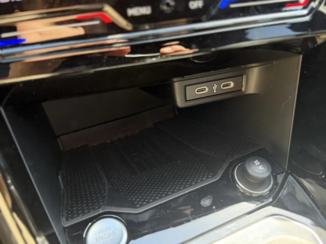 Gros plan sur la console centrale noire du Volkswagen T-Roc 2025, montrant ports USB-C, bouton start/stop et prise 12V.