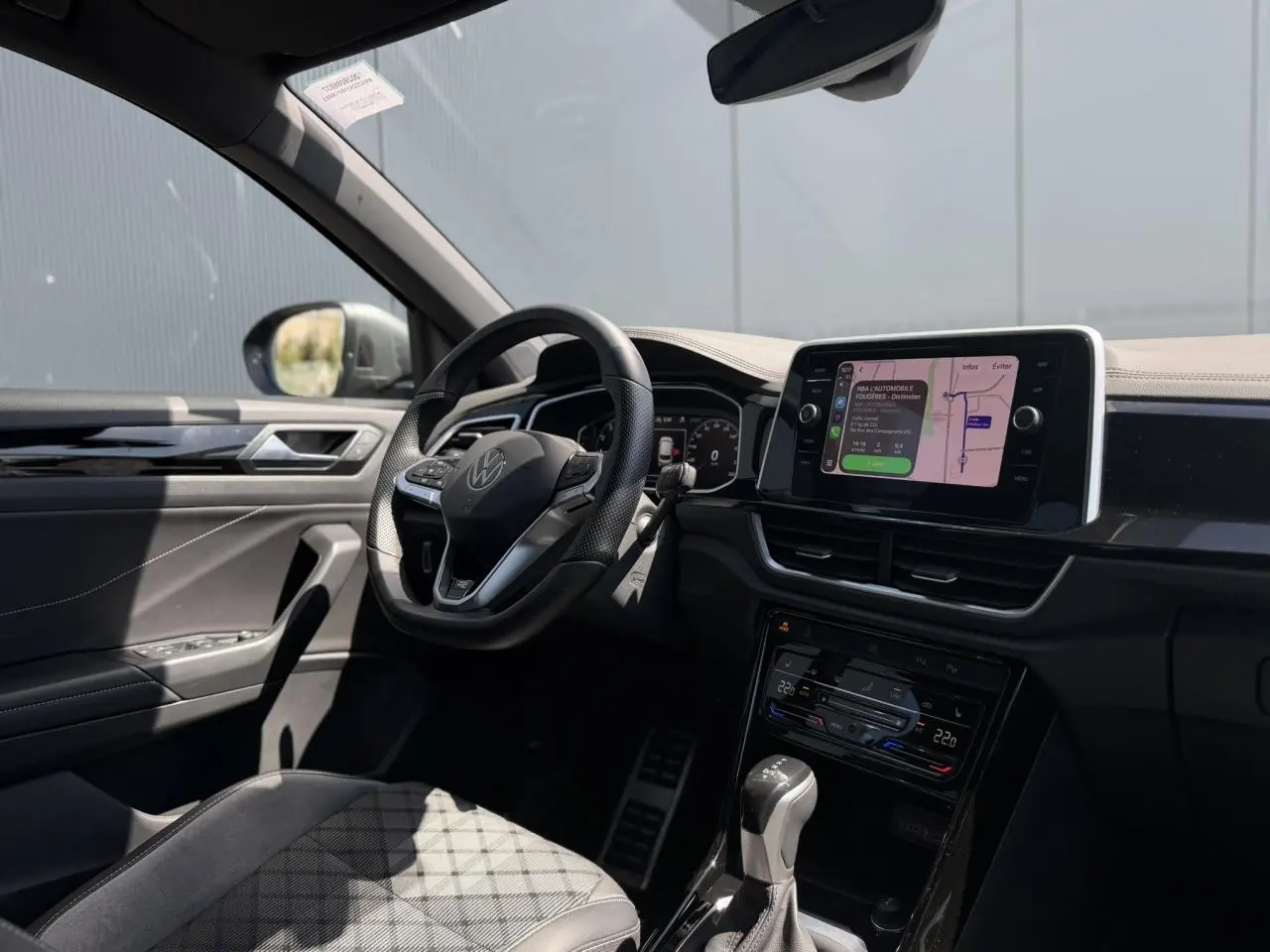 Vue intérieure côté conducteur du Volkswagen T-Roc 1.5 TSI R-Line avec volant cuir, écran tactile 8 pouces et tableau de bord digital.