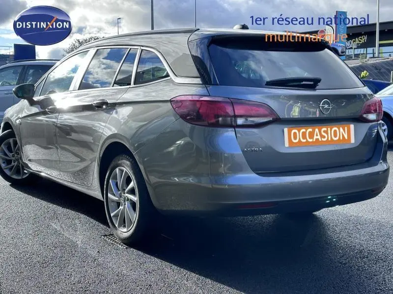 Vue 3/4 arrière droite d'une Opel Astra Sports Tourer gris cosmique avec feux arrière LED et jantes alu.