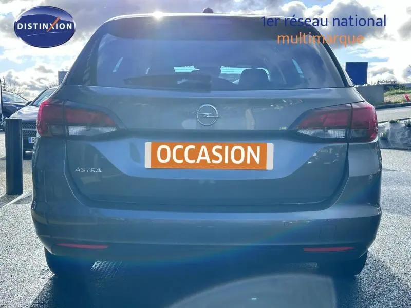 Vue arrière d'une Opel Astra Sports Tourer gris cosmique avec feux arrière LED et plaque "OCCASION" visible.