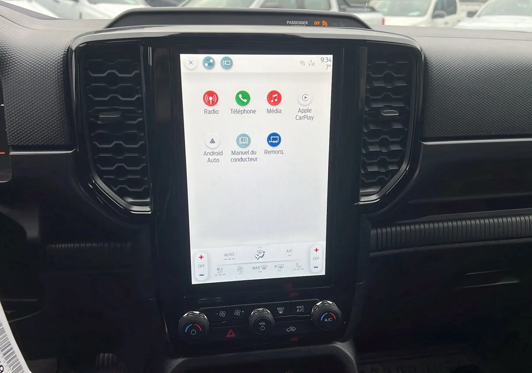 Vue rapprochée de l’écran tactile central du Ford Ranger 2025 bleu lightning avec commandes climatisation et connectivité Apple CarPlay.