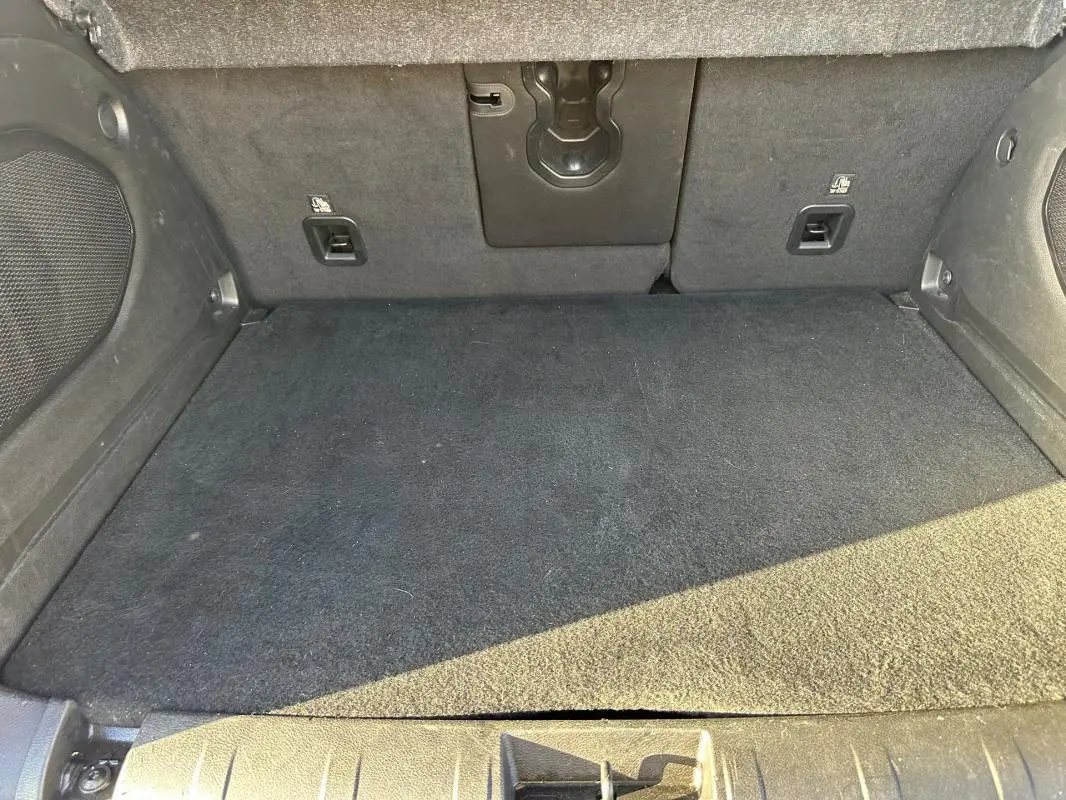 Vue intérieure du coffre noir du Jeep Renegade 2022, montrant le tapis et les fixations arrière.