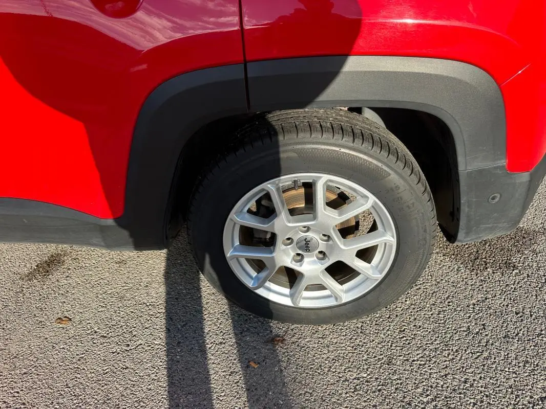 Gros plan sur la roue avant droite du Jeep Renegade rouge 2022 avec jante alliage 17 pouces.