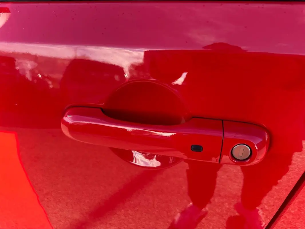 Poignée de porte rouge en gros plan sur une Jeep Renegade 2022, finition Limited diesel.