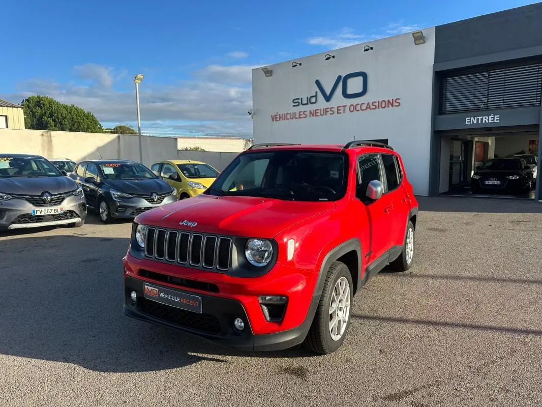 Jeep Renegade rouge vue 3/4 avant droit avec jantes alliage 17 pouces, stationné devant un concessionnaire.