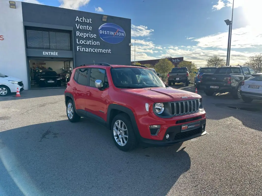 Jeep Renegade rouge vue 3/4 avant droit avec jantes alliage 17 pouces, stationné devant un garage.
