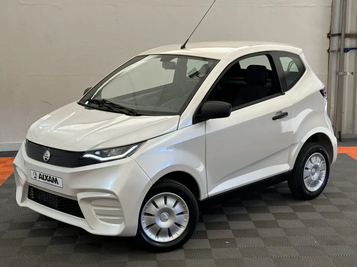Vue 3/4 avant d'une Aixam Ambition E City Pack blanche électrique avec rétroviseur caméra côté gauche.