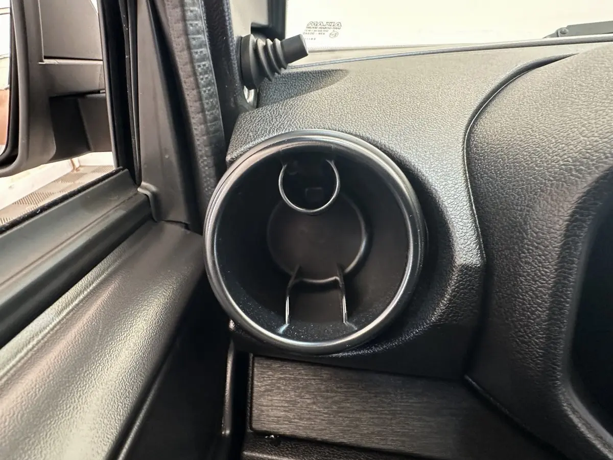 Gros plan sur la sortie d'air ronde côté conducteur de l'AIXAM AMBITION E CITY PACK 2025, intérieur noir.