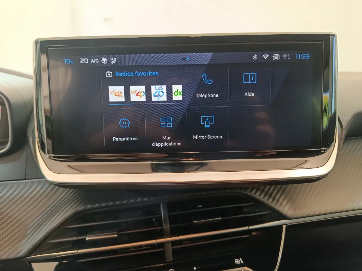 Écran tactile central de 10 pouces affichant le menu multimédia dans l’habitacle d’une Peugeot 208 gris foncé.