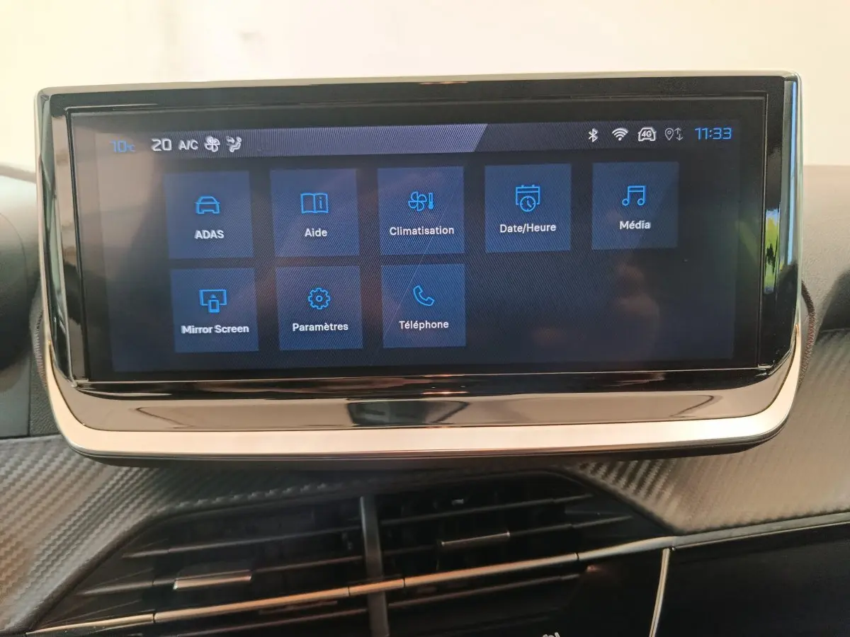 Écran tactile central de 10 pouces affichant les menus multimédias dans l’habitacle d’une Peugeot 208 gris foncé.
